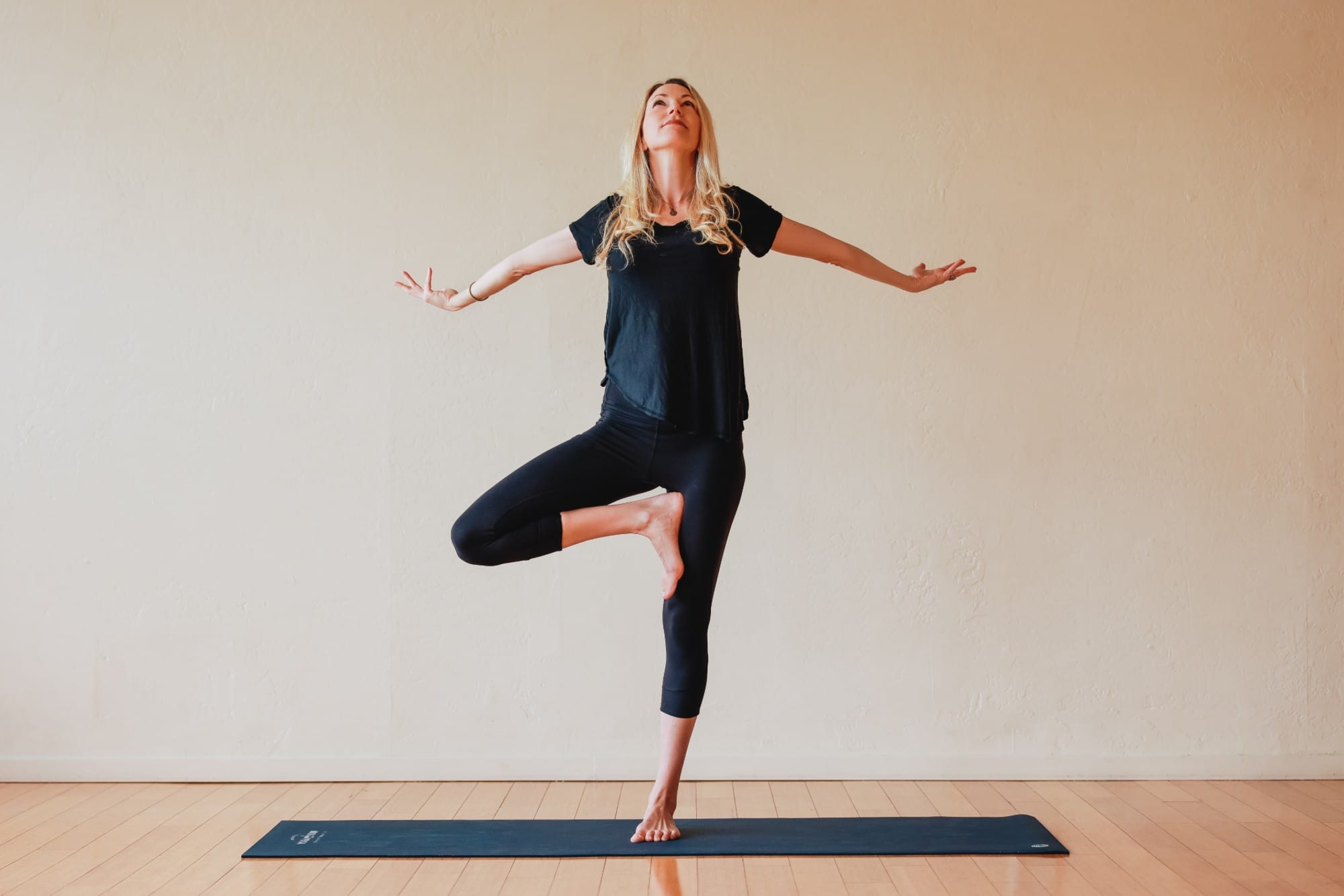 Kara in tree pose with her arms open